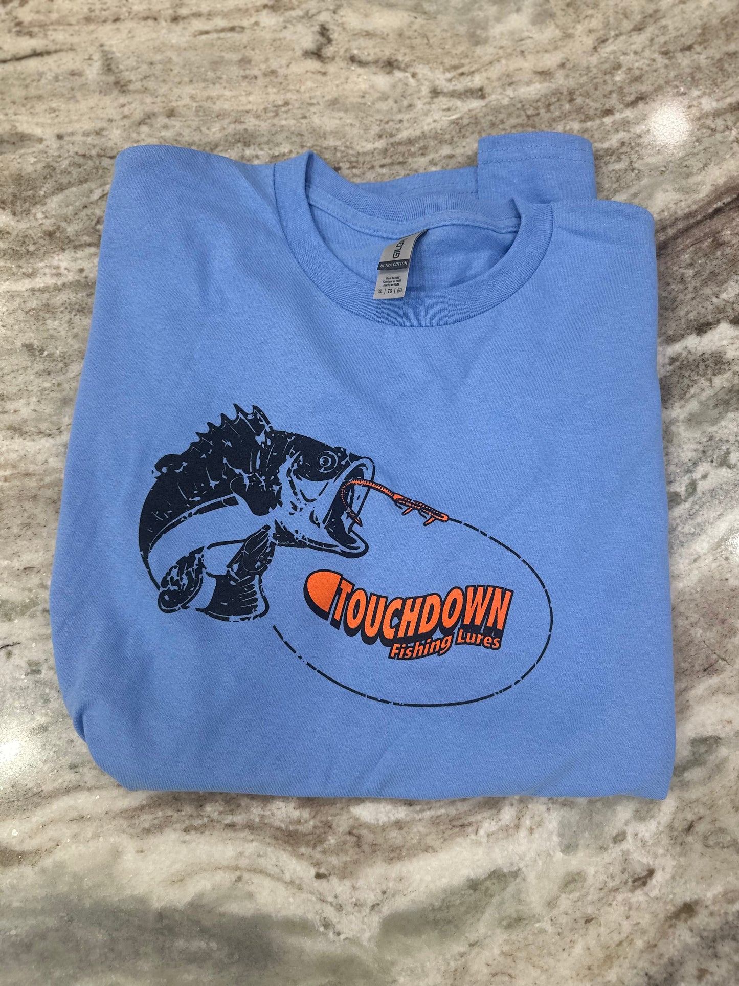 Short Sleeve Tee in Ultra Cotton Gildan T-shirt. Large Black and Bright Orange Touchdown logo on front of shirt. Now available in Graphite Heather (Gray), Antique Sapphire (Blue), and Caroline (Light) Blue in sizes from Youth-2XL.